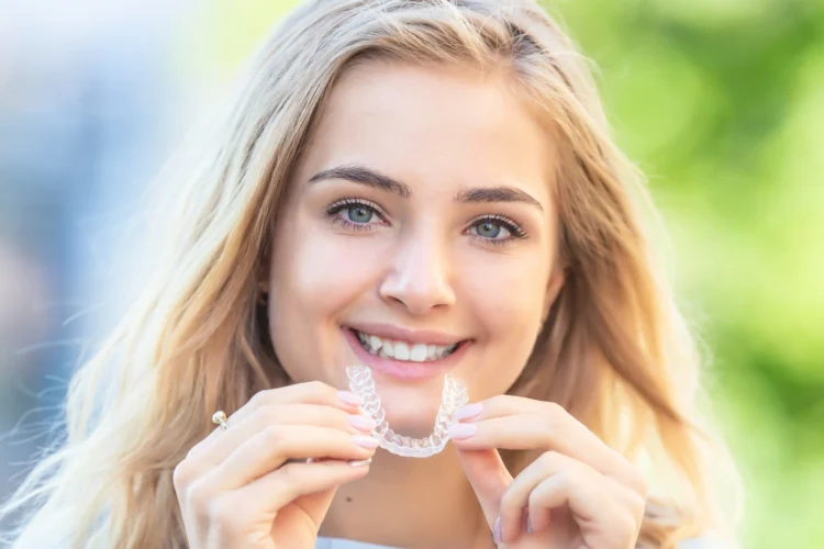 Teenager holding Invisalign clear aligners before treatment at a West Vancouver orthodontist